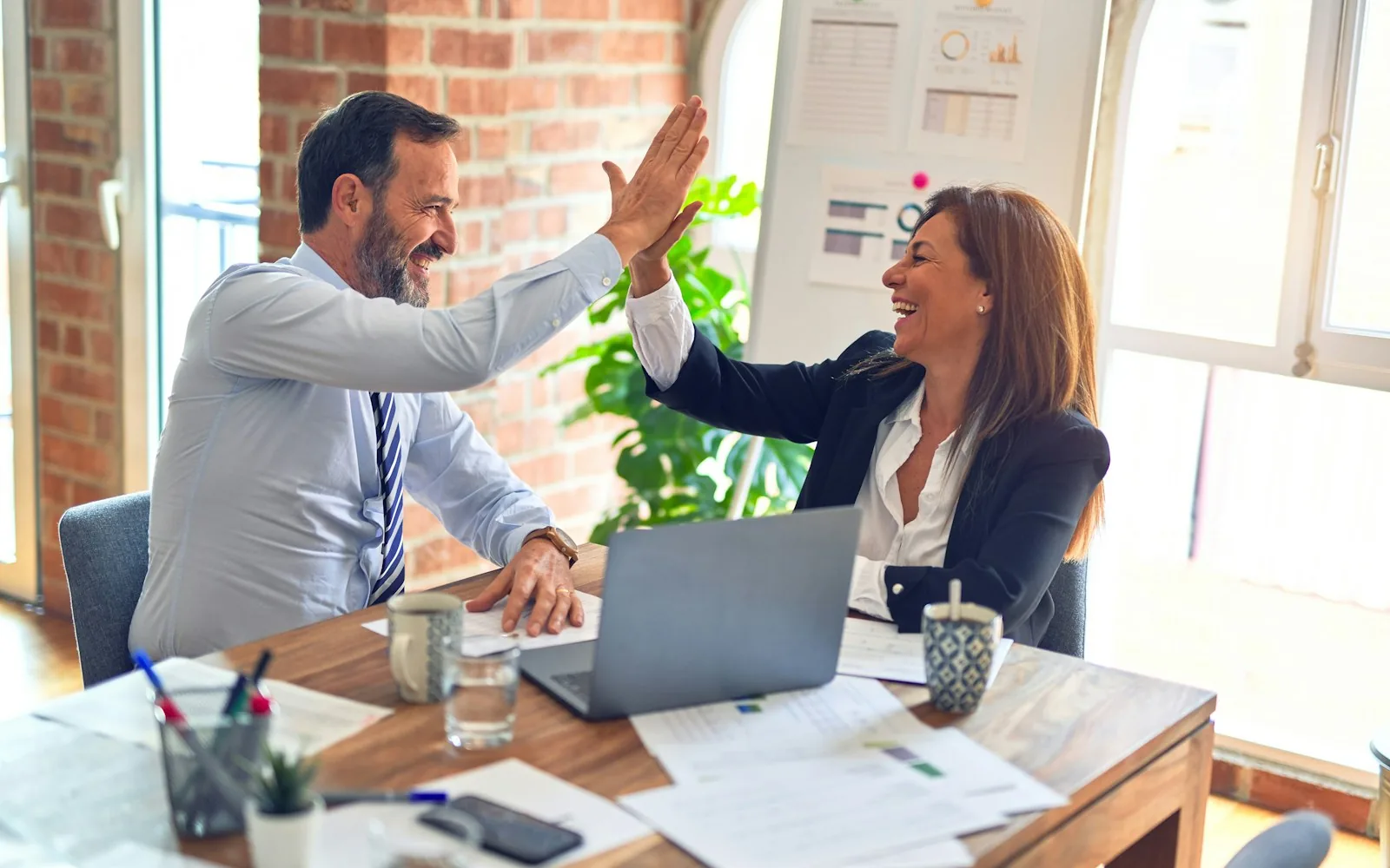 Two colleagues in a focused conversation about a hiring workflow