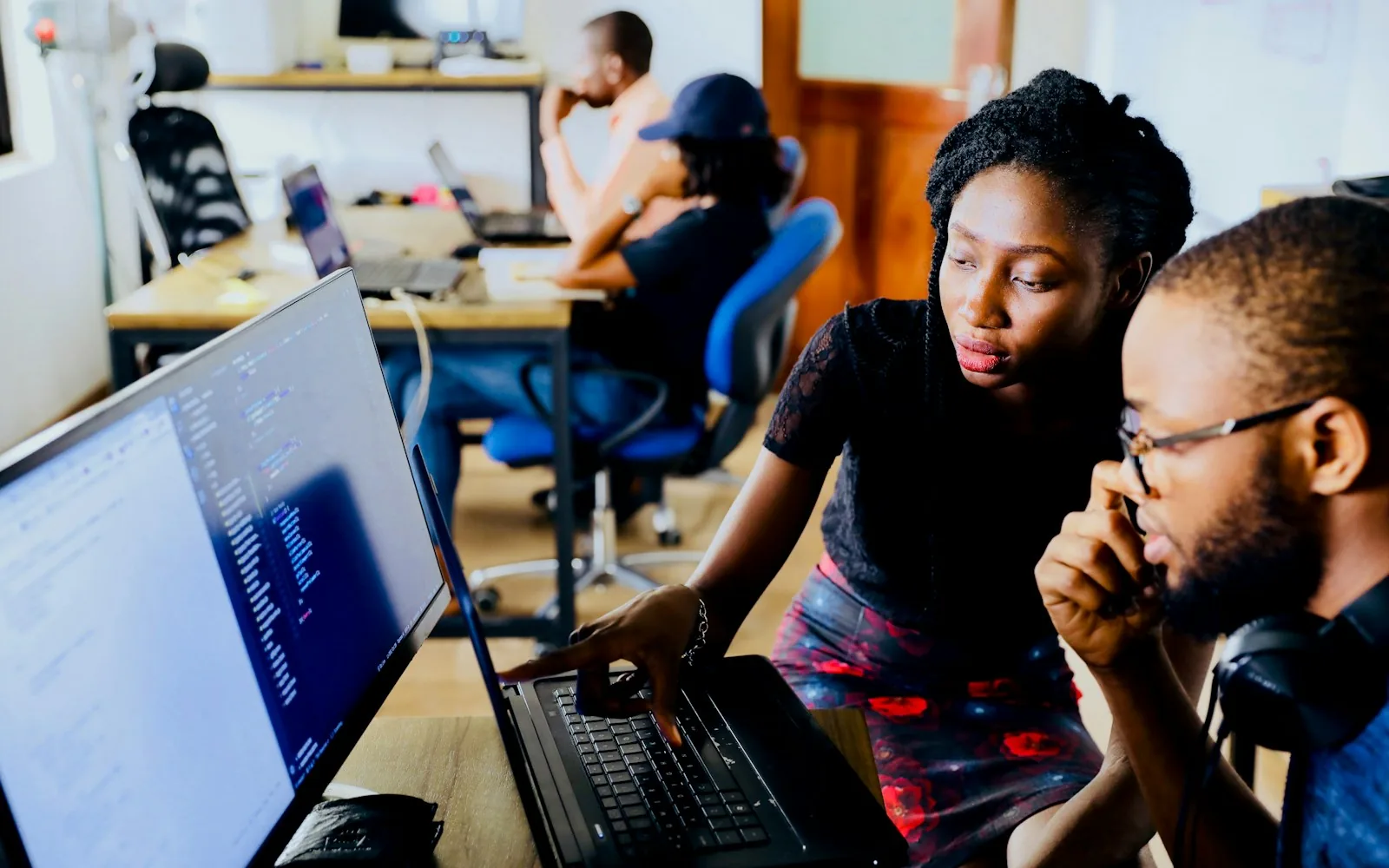 Two colleagues reviewing a recruiting workflow and candidate stages on screen