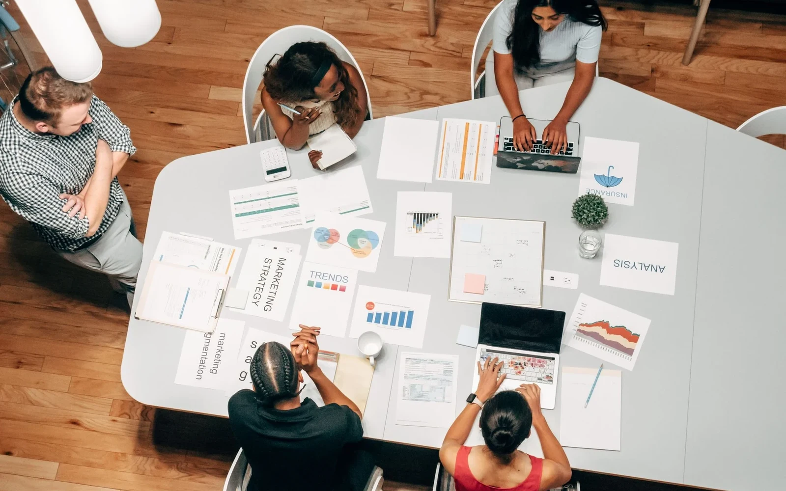 Team reviewing printed reports around a large meeting table